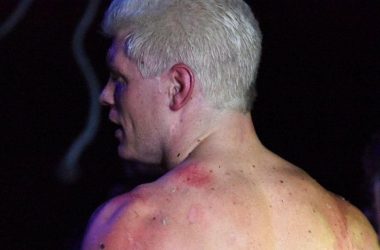 Cody Rhodes suplexes Andrade El Idolo through a flaming table; Photos of Cody's back
